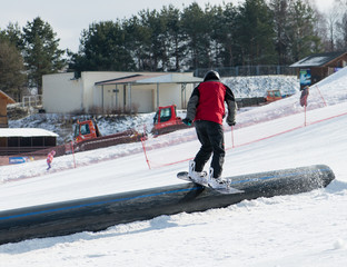 snowboarder slides on rails