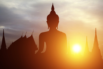 Silhouette of Buddha with sun shining from behind.