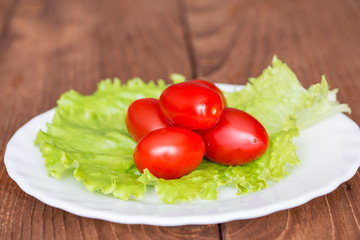 Помидоры и листья салата на тарелке