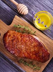Duck breast, lavender honey and thyme, served on chopping board. View From Above, Top Studio Shot