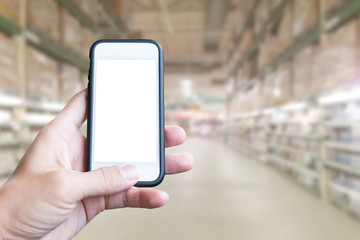 Hand holding smartphone with supermarket background