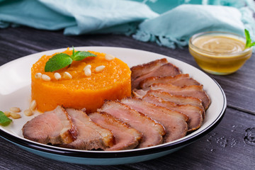 Roast duck breast and pumpkin mash, served with mint and pine nuts. Slices of duck with sweet butter squash, mustard and honey sauce