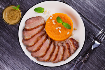 Roast duck breast and pumpkin mash, served with mint and pine nuts. Slices of duck with sweet...