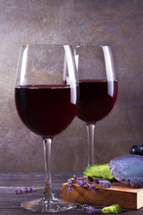 Glasses and bottle red  wine with lavender, pesto cheese and grape on chopping board. Wine and food still life