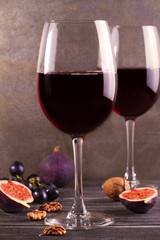 Glasses and bottle red  wine with lavender, pesto cheese and grape on chopping board. Wine and food still life in warm tones