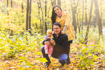 Fototapeta premium happy young family with their daughter spending time outdoor in the autumn park.