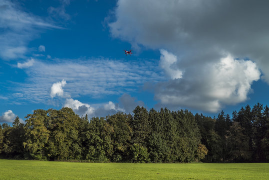 Quadrocopter in der Luft rückt den Schäfchenwolken auf den Pelz