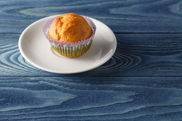Tasty cupcakes on plate, on light background