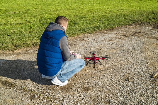 Junger Mann checkt seine Drohne vor dem Start