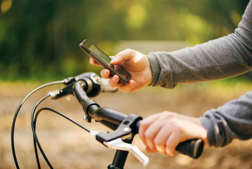 Woman typing text message during bicycle ride