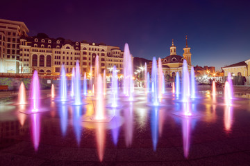 Fototapeta na wymiar Musical fountain with colorful illumination at night with reflection. Ukraine, Kiev. Travel entartainment sightseeing background