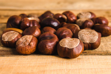 autumn brown chestnuts on an old wooden table