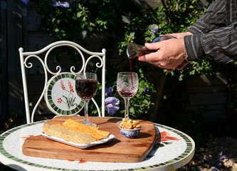 Wine Dear? Pouring red wine into glasses in garden