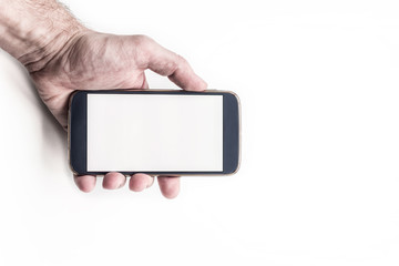 Hand holding mobile smartphone with blank screen horizontally on white background