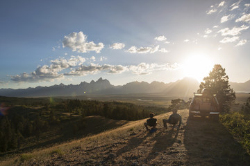 Rear view of friends sitting on field against sky