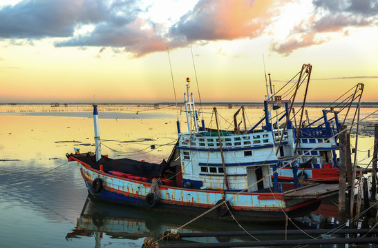 Fishing boats at port with sunset