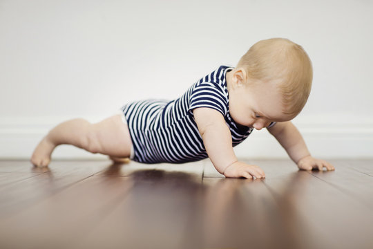 Baby boy exercising on floor at home