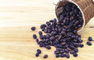 Closed up coffee bean in bamboo basket on wooden background.