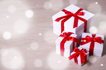 Christmas concept -present boxes with red ribbon on wooden backg