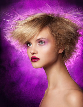 Portrait of woman with voluminous hair, black lit neon purple