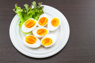 Close up medium soft boiled duck egg portion and green salad in dish