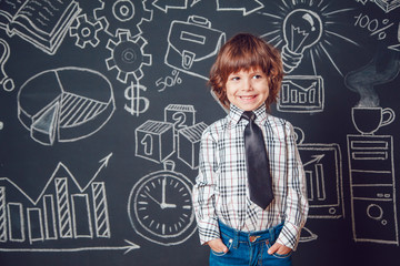 Little boy as businessman or teacher wearing shirt and tie on a dark background with business school picture
