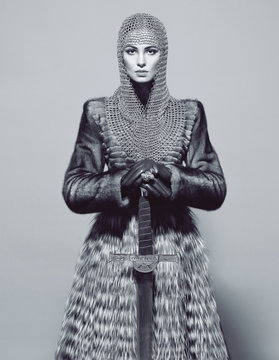 Woman posing in battle armour, studio shot, black and white 