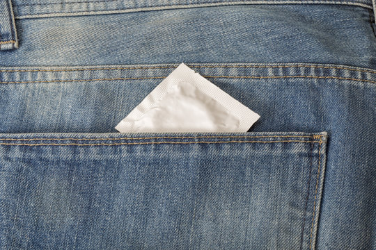 Condom in the pocket of a blue jeans closeup