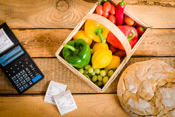 basket of vegetables on a wooden table with a cash register