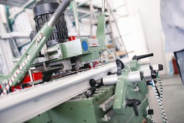 Manual worker cutting aluminum and PVC profiles. Manufacturing jobs. Selective focus. Factory for aluminum and PVC windows and doors production.