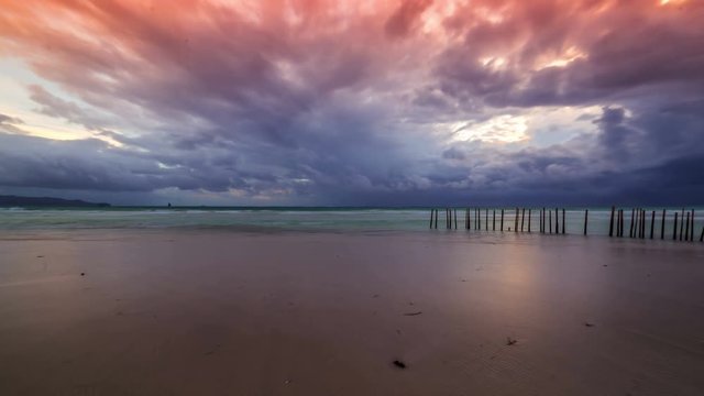 Walking people on sunset on a background of fence made of bamboo from the waves on the beach of Boracay Island, Philippines. 4K TimeLapse - August 2016, Boracay, Philippines