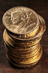 Swiss Vreneli gold coins on rustic wooden background