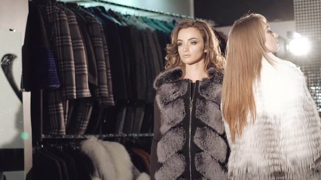 Two rich ladies posing and catwalk in fur coats