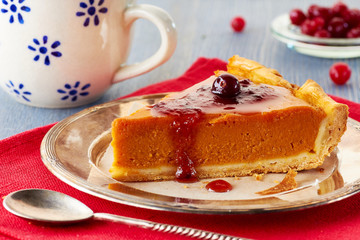 Homemade pumpkin pie with red currant jam and cranberries