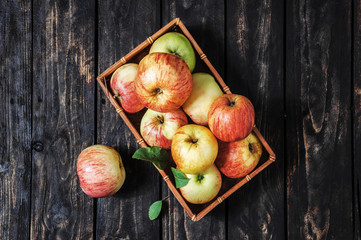 apples in a basket on the wooden background