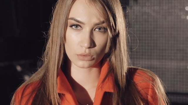Sexy model in red coat flirting and catwalking. Slowly