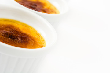 Traditional French creme brulee dessert with caramelized sugar on top, isolated on white background.
