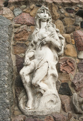 Fototapeta na wymiar Modern sculpture of Eve. Dressing stone wall sculpture