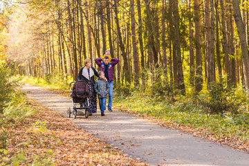 Obraz premium walking family with two children in autumnal park