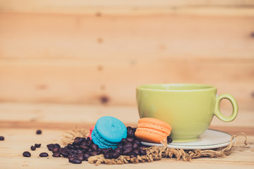 black coffee with macarons dessert on wood background.