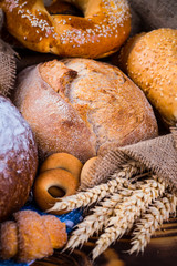 Assortment of baked bread on wooden table background
