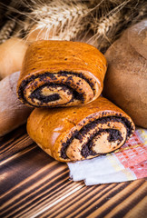Assortment of baked bread on wooden table background