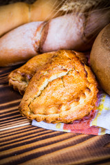 Assortment of baked bread on wooden table background