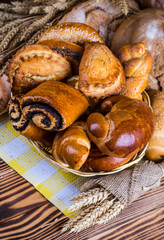 Assortment of baked bread on wooden table background