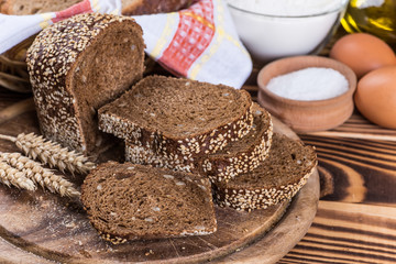 Assortment of baked bread on wooden table background