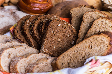 Assortment of baked bread on wooden table background