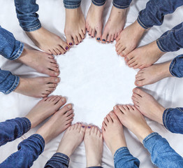 feet of girls with jeans in a circle