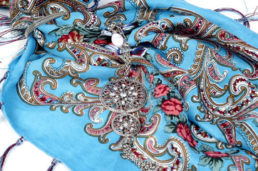 Thin wool kerchief and pendant on white background