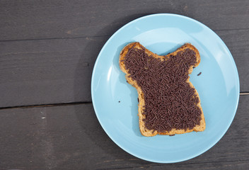 Typical Dutch bread with chocolate hagelslag on wooden background