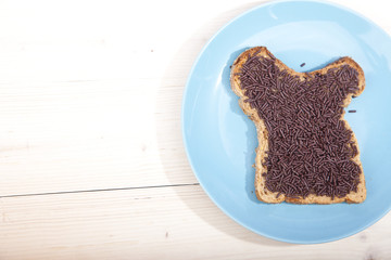 Typical Dutch bread with chocolate hagelslag on wooden background